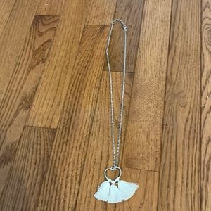 silver necklace with a heart and pom poms coming off of the heart